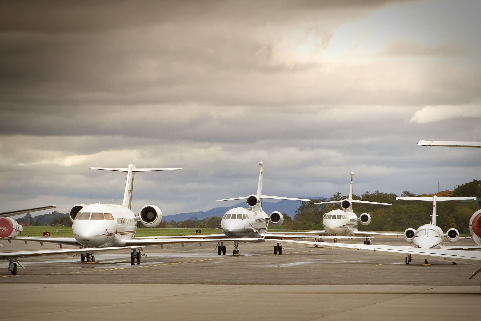 Six aircrafts lined up on tarmac on an overcast day