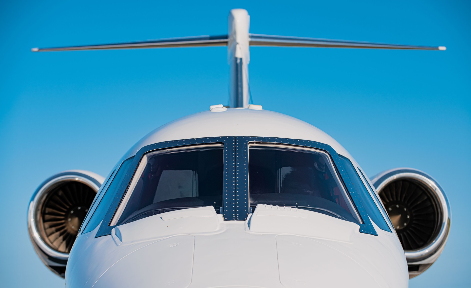 Nose and cockpit and two high mounted engines of a small business jet.