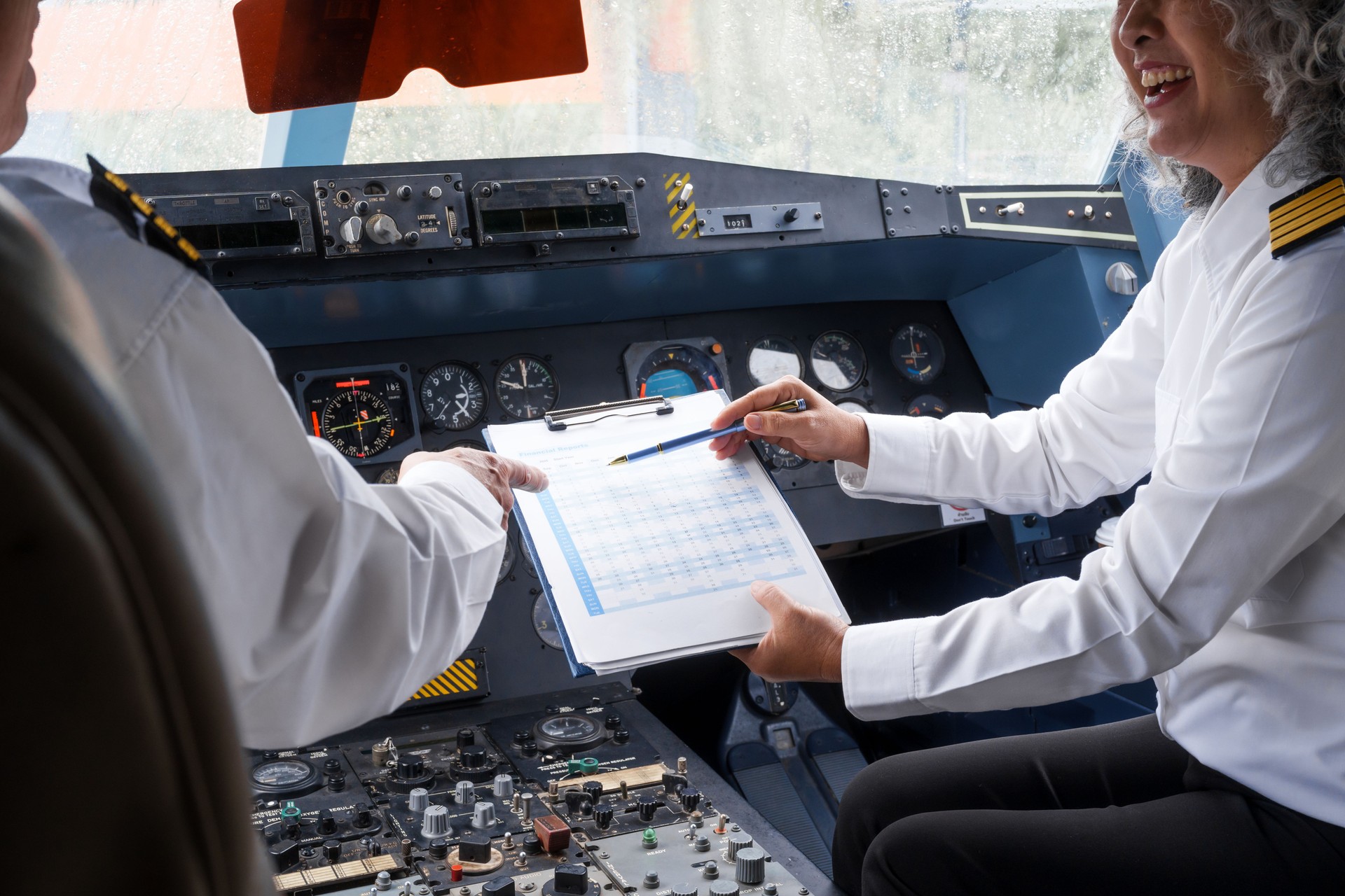 Mature male and female pilots meet inside an airplane, holding hands. Their gesture signifies teamwork, trust, and camaraderie in aviation, fostering a safe and collaborative work environment.